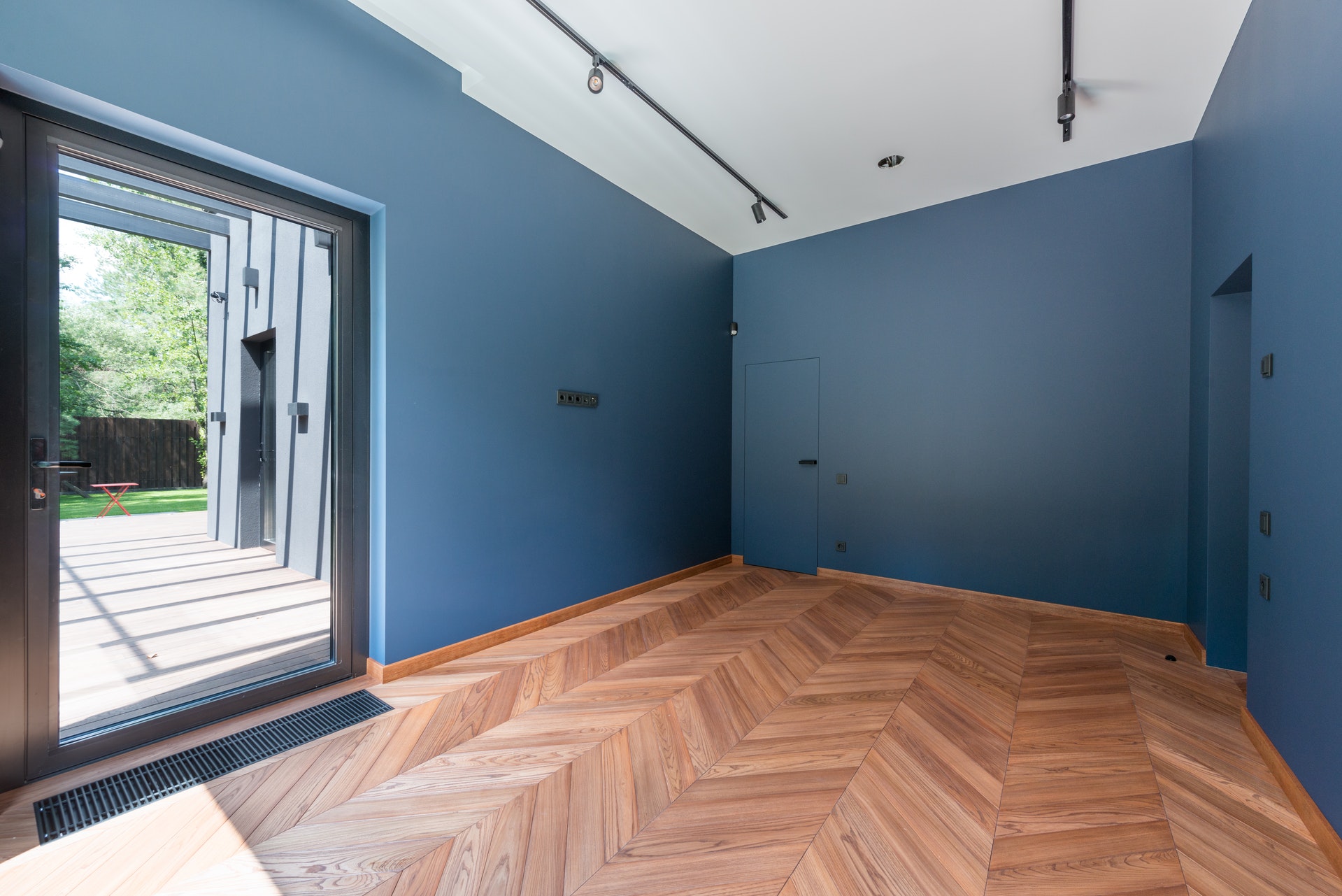 Pièce rénovée avec pose de parquet et peinture bleue aux murs